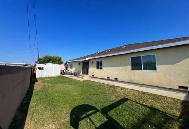 1019 W Arbutus St, Compton, CA 90220 - rear view of house with a shed, a fenced backyard, stucco siding, and a patio