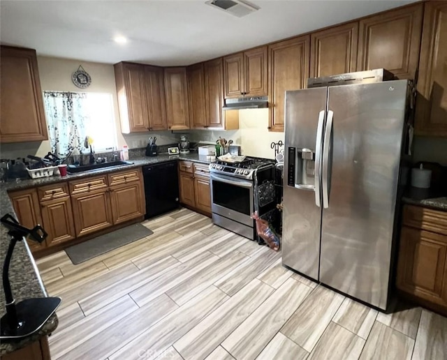 1019 W Arbutus St, Compton, CA 90220 - kitchen featuring appliances with stainless steel finishes, under cabinet range hood, brown cabinets, dark countertops, and wood finish floors