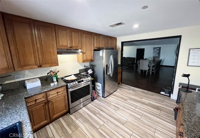 1019 W Arbutus St, Compton, CA 90220 - kitchen with appliances with stainless steel finishes, under cabinet range hood, brown cabinetry, and light wood finished floors