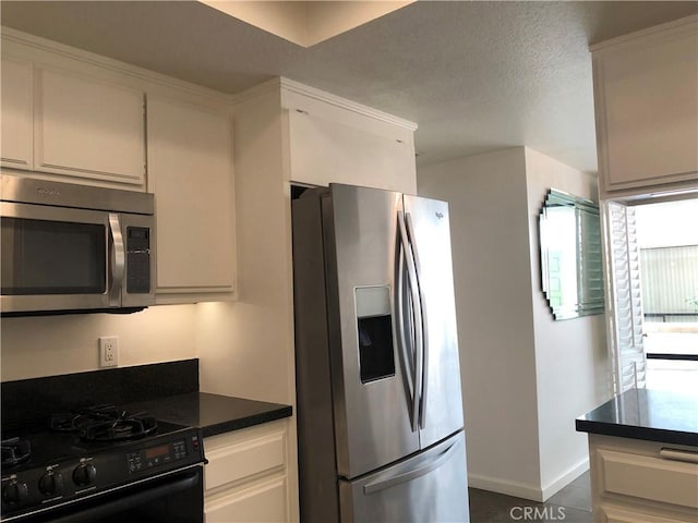 2545 Via Campesina Unit 102, Palos Verdes Estates, CA 90274 - kitchen featuring appliances with stainless steel finishes, dark countertops, and white cabinetry