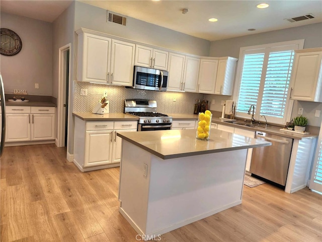 26523 Starling Ct, Canyon Country, CA 91387 - kitchen with appliances with stainless steel finishes, white cabinetry, light wood-style floors, and recessed lighting