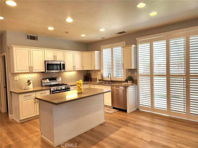 26523 Starling Ct, Canyon Country, CA 91387 - kitchen featuring stainless steel appliances, light wood-style floors, backsplash, recessed lighting, and white cabinets