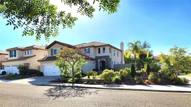 26523 Starling Ct, Canyon Country, CA 91387 - view of front facade with concrete driveway, an attached garage, stucco siding, and stone siding
