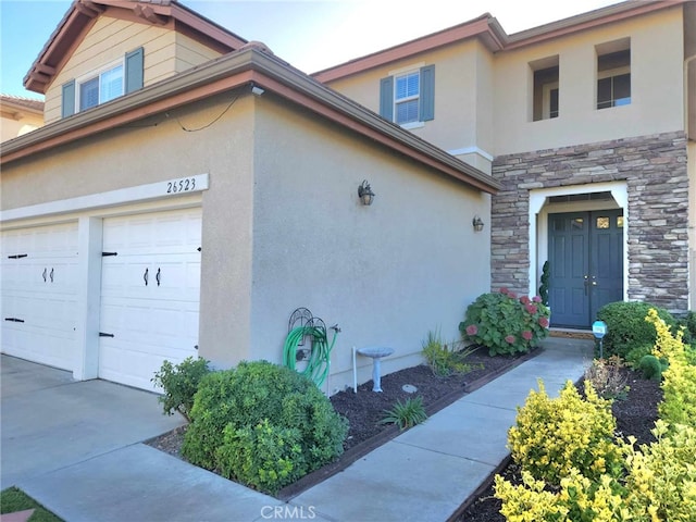 26523 Starling Ct, Canyon Country, CA 91387 - view of side of home featuring stone siding, stucco siding, and an attached garage