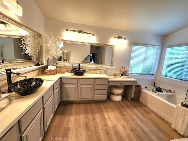 26523 Starling Ct, Canyon Country, CA 91387 - bathroom with wood finished floors, double vanity, a garden tub, and vaulted ceiling