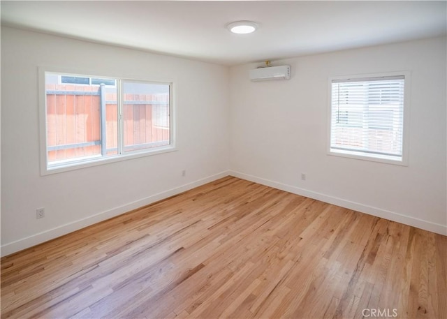 1522 N Benton Way, Los Angeles, CA 90026 - empty room with an AC wall unit and light wood-style floors