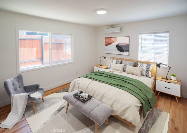 1522 N Benton Way, Los Angeles, CA 90026 - bedroom with multiple windows, an AC wall unit, and light wood-style flooring