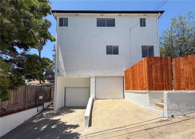 1522 N Benton Way, Los Angeles, CA 90026 - view of front facade with stucco siding, an attached garage, and concrete driveway