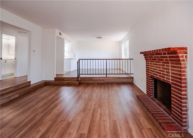 1522 N Benton Way, Los Angeles, CA 90026 - unfurnished living room with wood finished floors and a brick fireplace