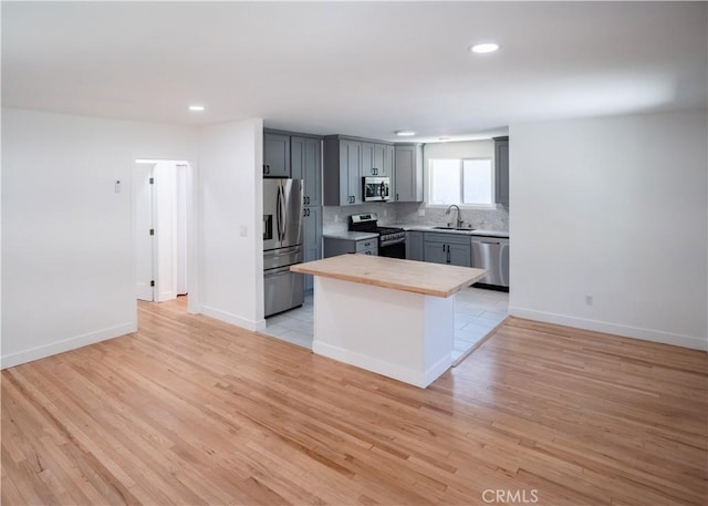 1522 N Benton Way, Los Angeles, CA 90026 - kitchen featuring stainless steel appliances, recessed lighting, backsplash, light wood-style flooring, and gray cabinetry