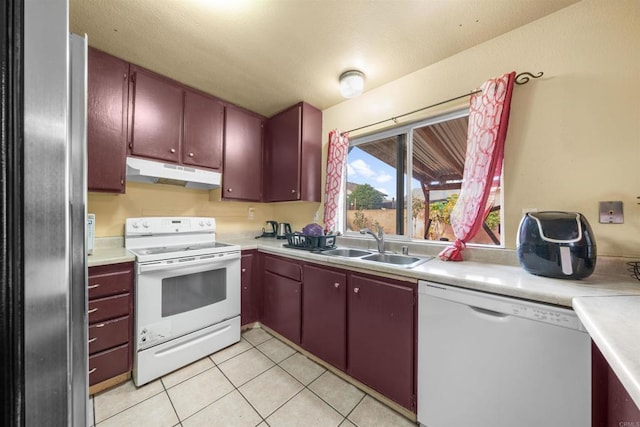 1861 Katella St, San Diego, CA 92154 - kitchen with white appliances, under cabinet range hood, light countertops, and light tile patterned flooring