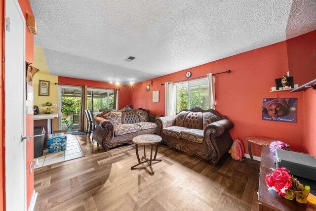 1861 Katella St, San Diego, CA 92154 - living room featuring plenty of natural light, a textured ceiling, and wood finished floors
