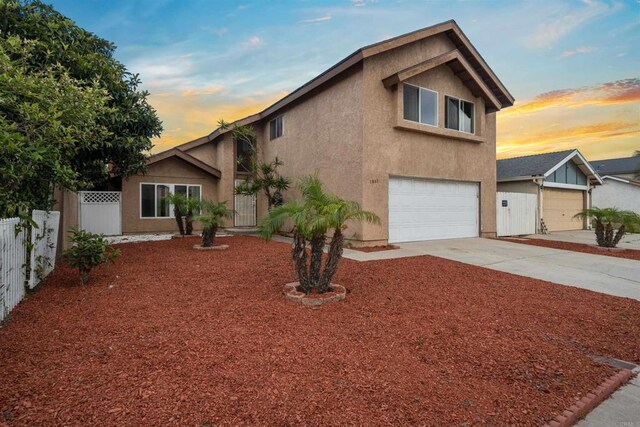 1861 Katella St, San Diego, CA 92154 - view of front of house with stucco siding, an attached garage, and concrete driveway