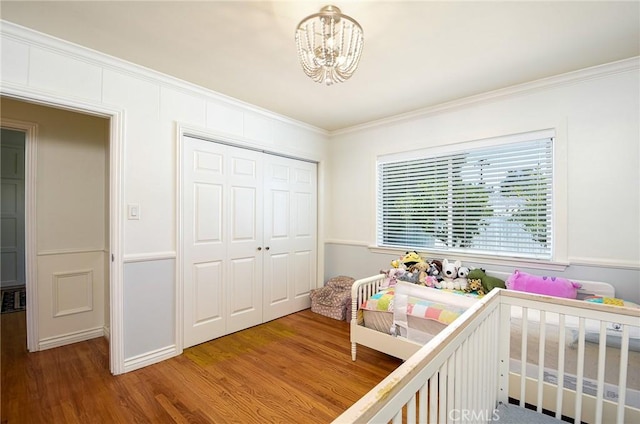 7311 Westwood Dr, Riverside, CA 92504 - bedroom featuring crown molding, a closet, a chandelier, wood finished floors, and a crib