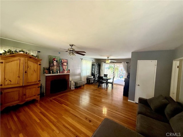 8514 Hickory Ln, Riverside, CA 92504 - living room featuring a ceiling fan, light wood finished floors, and a brick fireplace