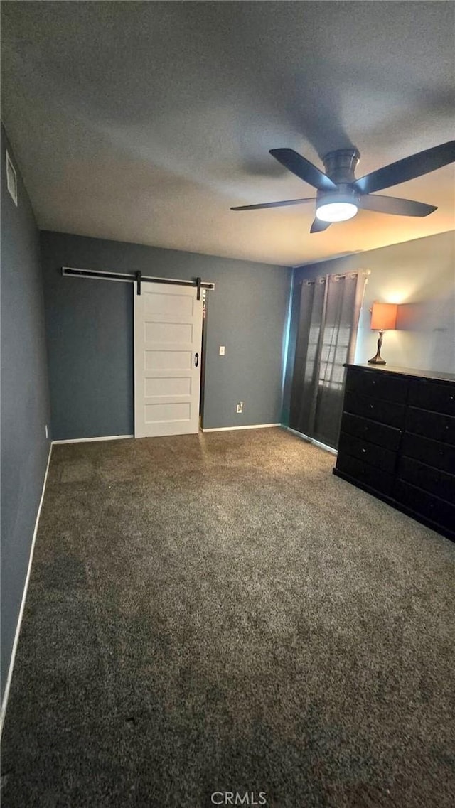 8514 Hickory Ln, Riverside, CA 92504 - unfurnished bedroom with a barn door, carpet floors, a ceiling fan, and a textured ceiling