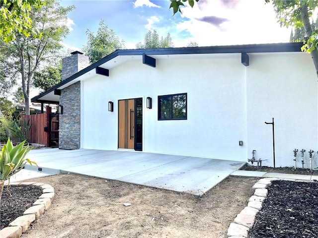10335 Babbitt Ave, Granada Hills, CA 91344 - back of house with a chimney, a patio, stucco siding, and stone siding