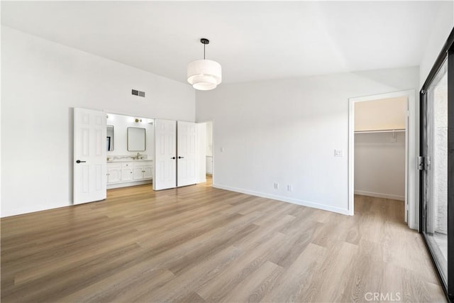 5510 Las Virgenes Rd, Calabasas, CA 91302 - unfurnished bedroom featuring light wood finished floors, a walk in closet, ensuite bath, and a closet