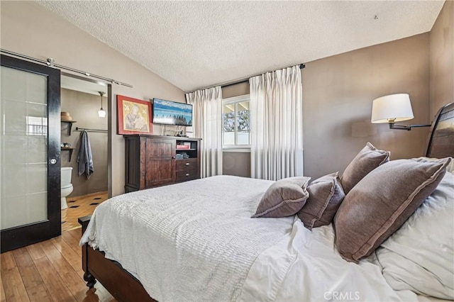2148 W Houston Ave, Fullerton, CA 92833 - bedroom with a textured ceiling, hardwood / wood-style flooring, lofted ceiling, and ensuite bathroom