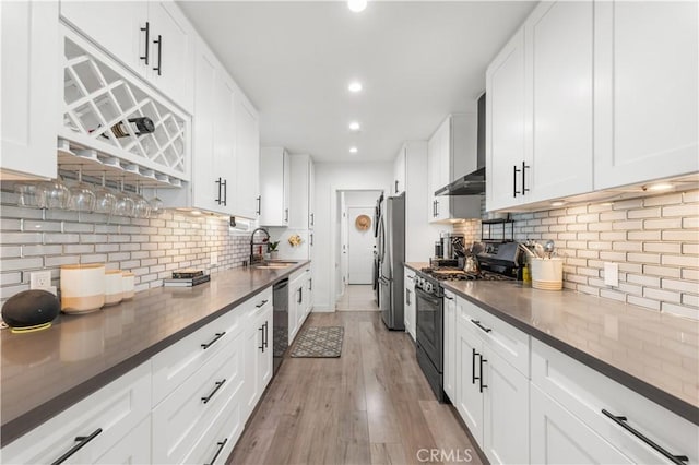 15018 Mankato St, Mission Hills San Fernando, CA 91345 - kitchen featuring range with gas cooktop, wall chimney exhaust hood, freestanding refrigerator, dishwashing machine, and tasteful backsplash