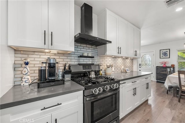 15018 Mankato St, Mission Hills San Fernando, CA 91345 - kitchen with wall chimney range hood, gas range oven, white cabinets, dark countertops, and tasteful backsplash