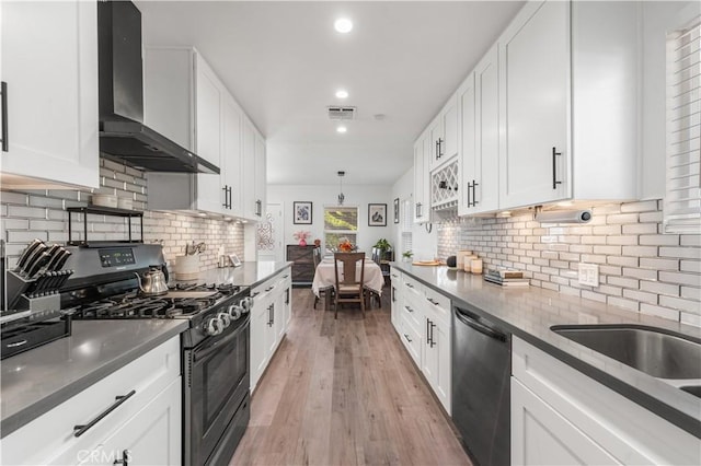 15018 Mankato St, Mission Hills San Fernando, CA 91345 - kitchen with wall chimney range hood, black gas stove, dishwasher, white cabinets, and recessed lighting