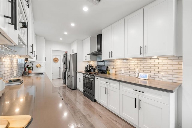 15018 Mankato St, Mission Hills San Fernando, CA 91345 - kitchen featuring appliances with stainless steel finishes, wall chimney exhaust hood, stacked washer / drying machine, backsplash, and recessed lighting