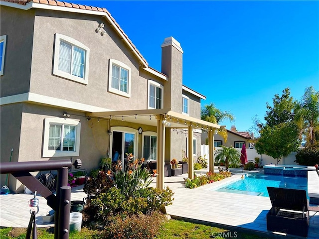 1539 Carmel Ct, Redlands, CA 92374 - rear view of house featuring stucco siding, a chimney, a pool with connected hot tub, and a patio area
