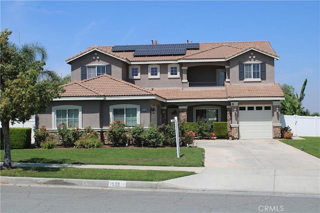 1539 Carmel Ct, Redlands, CA 92374 - mediterranean / spanish house featuring stucco siding, roof mounted solar panels, driveway, and a tile roof