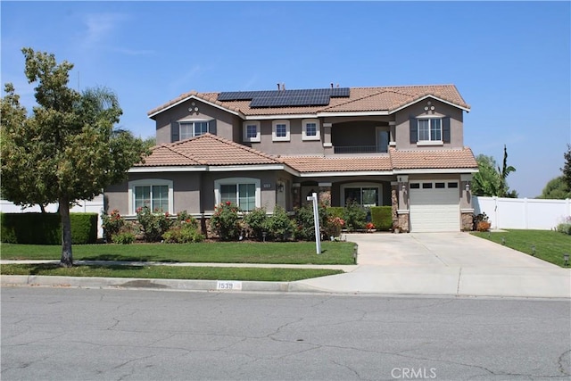 1539 Carmel Ct, Redlands, CA 92374 - mediterranean / spanish-style house featuring stucco siding, solar panels, concrete driveway, a tile roof, and an attached garage