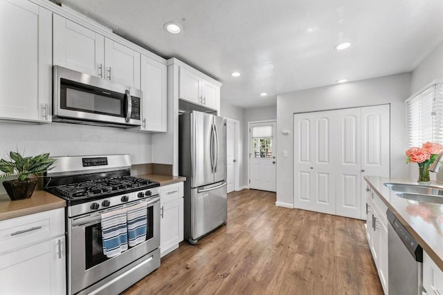 4117 Jamul Ave, San Diego, CA 92113 - kitchen featuring stainless steel appliances, white cabinets, light wood-type flooring, recessed lighting, and light countertops