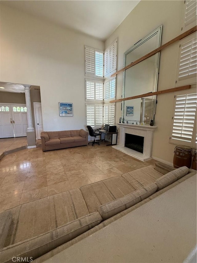 22241 Birchleaf, Mission Viejo, CA 92692 - tiled living room with a high ceiling, decorative columns, and a fireplace with raised hearth