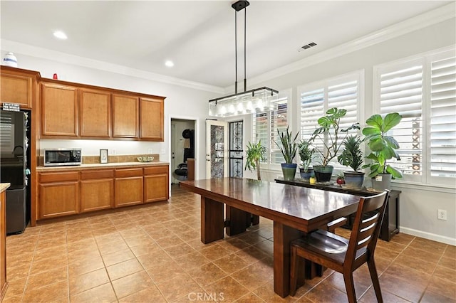 17024 Granite Falls Way, Chowchilla, CA 93610 - kitchen featuring fridge, stainless steel microwave, brown cabinetry, ornamental molding, and decorative light fixtures