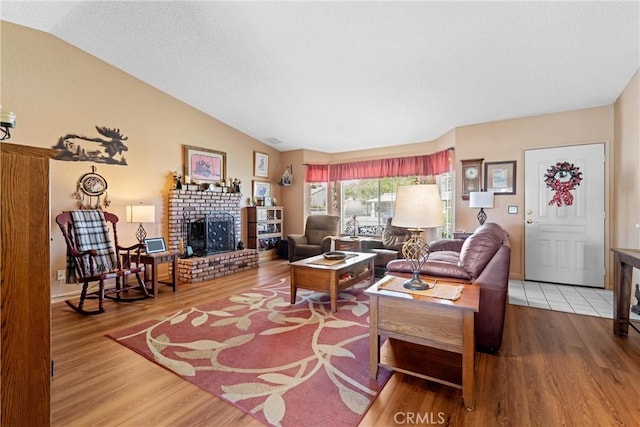 36916 95th St E, Littlerock, CA 93543 - living room featuring wood finished floors, a brick fireplace, and lofted ceiling