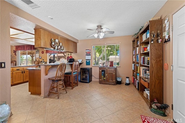 36916 95th St E, Littlerock, CA 93543 - kitchen featuring a breakfast bar, ceiling fan, a textured ceiling, a peninsula, and plenty of natural light