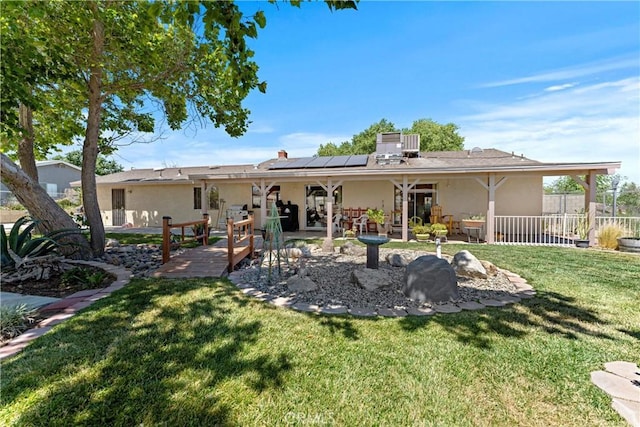 36916 95th St E, Littlerock, CA 93543 - back of property with stucco siding, roof mounted solar panels, and a patio area