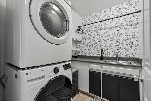 27318 Chesterfield Dr, Valencia, CA 91354 - laundry room featuring stacked washer / dryer, cabinet space, wallpapered walls, and light tile patterned flooring