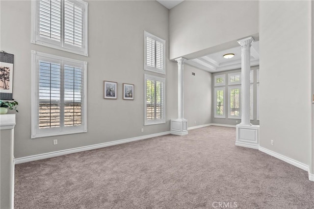 27318 Chesterfield Dr, Valencia, CA 91354 - empty room featuring ornate columns, carpet floors, a tray ceiling, and a high ceiling