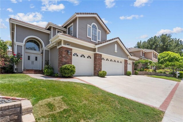 27318 Chesterfield Dr, Valencia, CA 91354 - view of front of home featuring brick siding, a front lawn, concrete driveway, an attached garage, and entry steps