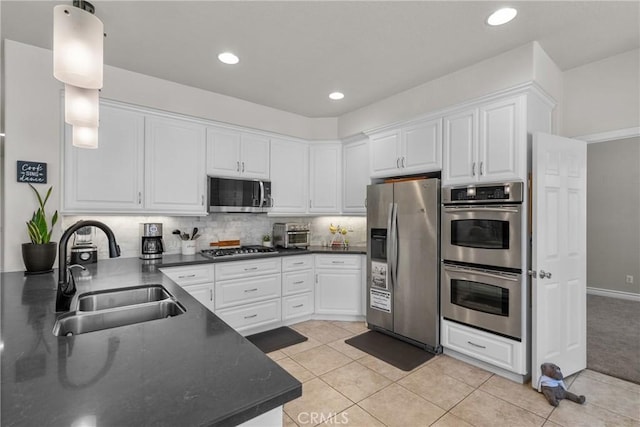 27318 Chesterfield Dr, Valencia, CA 91354 - kitchen featuring appliances with stainless steel finishes, dark countertops, white cabinetry, light tile patterned flooring, and recessed lighting
