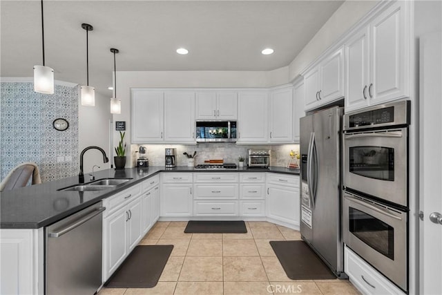 27318 Chesterfield Dr, Valencia, CA 91354 - kitchen featuring stainless steel appliances, a peninsula, dark countertops, and white cabinetry