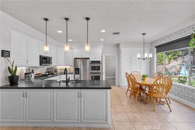 27318 Chesterfield Dr, Valencia, CA 91354 - kitchen with appliances with stainless steel finishes, a peninsula, dark countertops, white cabinets, and recessed lighting