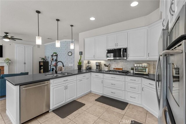 27318 Chesterfield Dr, Valencia, CA 91354 - kitchen with stainless steel appliances, dark countertops, a peninsula, tasteful backsplash, and white cabinets