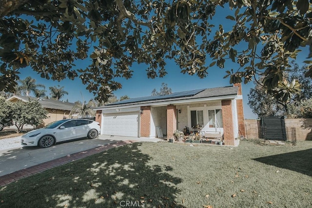 2438 Emerson Cir, Corona, CA 92882 - ranch-style house featuring brick siding, concrete driveway, an attached garage, and roof mounted solar panels