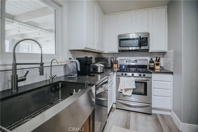 2438 Emerson Cir, Corona, CA 92882 - kitchen with stainless steel appliances, dark countertops, light wood-style floors, and decorative backsplash