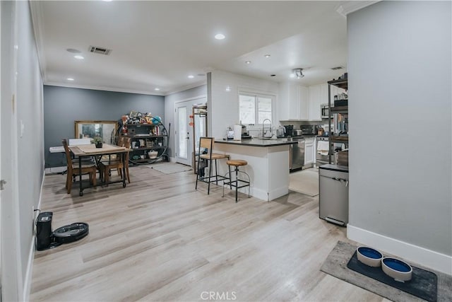 2438 Emerson Cir, Corona, CA 92882 - kitchen featuring white cabinetry, a breakfast bar area, dark countertops, a peninsula, and crown molding