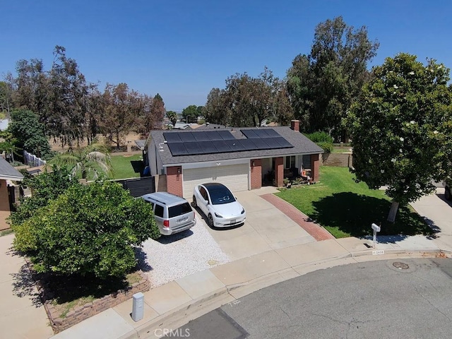 2438 Emerson Cir, Corona, CA 92882 - view of front of home featuring a front lawn, roof mounted solar panels, driveway, an attached garage, and roof with shingles