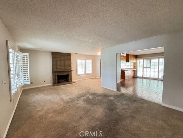 8641 Limestone Dr, Riverside, CA 92504 - unfurnished living room featuring carpet floors, a fireplace, and a textured ceiling