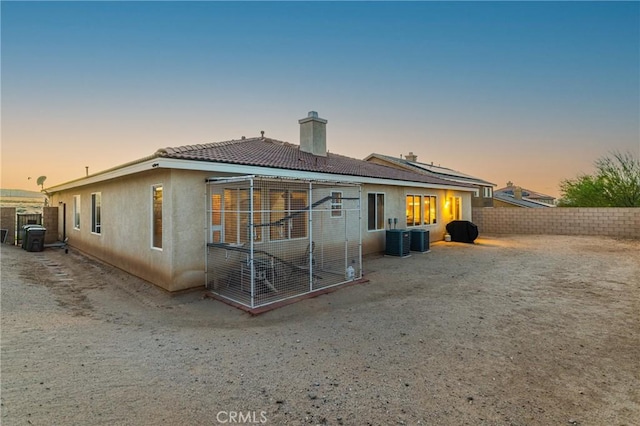 42432 72nd St W, Lancaster, CA 93536 - back of property at dusk with a chimney, a fenced backyard, stucco siding, and a tiled roof