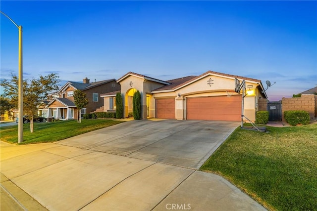 42432 72nd St W, Lancaster, CA 93536 - mediterranean / spanish-style house with stucco siding, concrete driveway, an attached garage, and a tile roof